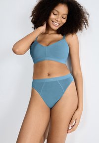 Blå sømløs bh med justerbare stropper og matchende højtaljede trusser. Blødt, elastisk materiale med diskret logo detalje på livet.