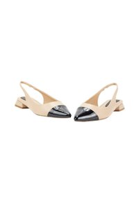Zapatos slingback beige con punta afilada, que presentan una puntera de charol negro y un pequeño tacón cuadrado. Textura suave, diseño minimalista.