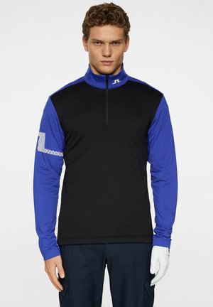 Black and blue long-sleeve shirt with high collar, half zipper, textured black body, blue sleeves, and striped detail on the left arm.