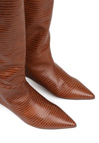 Brązowe, teksturowane skórzane kozaki za kolano z szpiczastym noskiem i pionowym wzorem w paski. Gładkie wykończenie z delikatnym połyskiem.