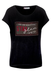 Černé tričko s krátkým rukávem a kulatým výstřihem, na přední straně s tiskem v červených a stříbrných kamíncích, který obsahuje text a obdélníkový rámeček.