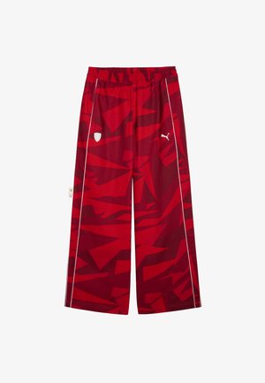 Red patterned wide-leg pants with an elastic waistband, featuring white accents and logos on the front. Made of lightweight fabric.