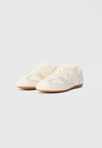 Superge kremne barve z gladko teksturo, okrašene z antilopnimi poudarki in elegantno zasnovo. Videz dopolnjujejo vezalke in gumijasti podplat.