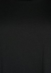 Textúra pevnej čiernej látky s miernymi záhybmi, ukazujúca jemný pletený materiál a jemné odtiene tieňa.