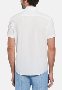 Korte mouwen wit shirt van lichte stof, met een rugpand en een gebogen zoomlijn met een lichte doorschijnendheid.