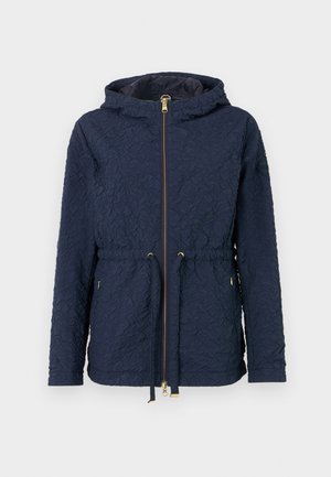 Tumedast sinine jakk tekstuurse kangaga, lukuga kinnistus, reguleeritav nööriga vöökoht ja kapuuts. Toode sisaldab kuldset tooni aktsente ja paigaldust varrukal.