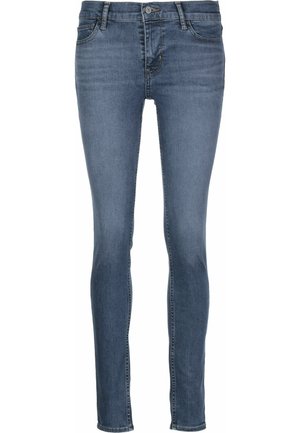 Jeans ajustados de mezclilla azul con una cintura de altura media, cinco bolsillos y un ligero desvanecimiento. Presentan un cierre con cremallera y botón de metal.