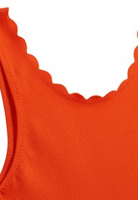 Tissu de maillot de bain orange vif avec une surface texturée. Présente un décolleté festonné et des coutures lisses le long des bords.