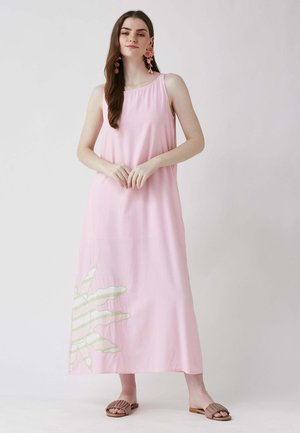 Robe maxi rose à coupe décontractée, arborant un motif de feuilles vertes sur le côté inférieur gauche. Fabriquée en tissu léger, avec un décolleté arrondi et sans manches.