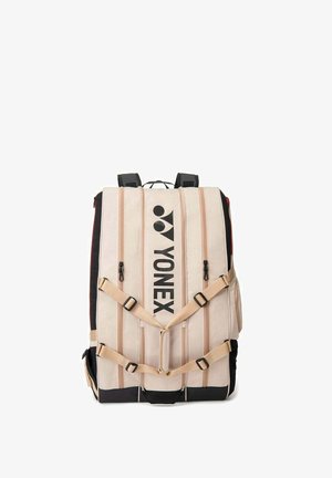 Zaino Yonex beige e nero con molteplici scomparti verticali con cerniera e cinghie anteriori regolabili.
