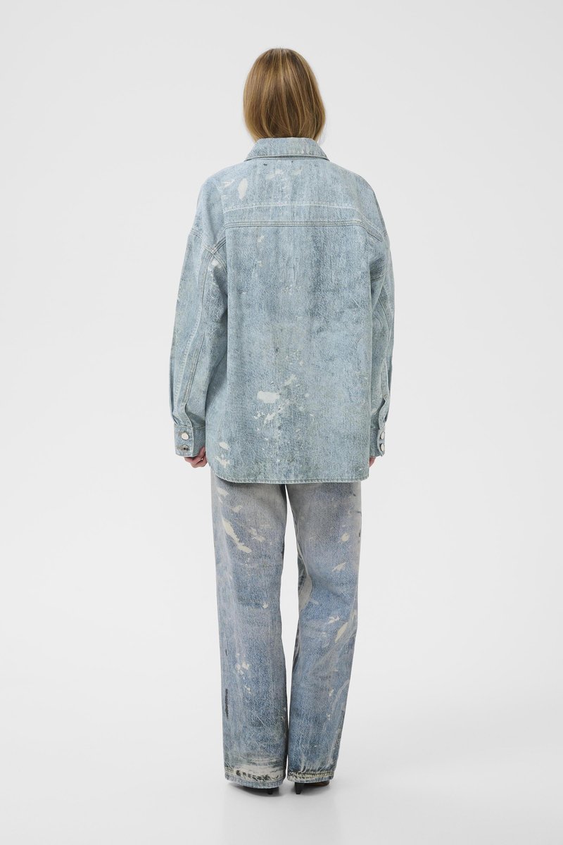 Veste en denim bleu clair et pantalon assorti avec détails usés. Les deux vêtements présentent une coupe décontractée et une texture délavée.