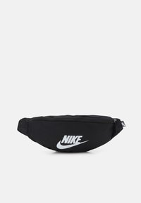 Svart nylontask för midjan med rundad form, med en vit Nike-logotyp på framsidan. Inkluderar dragkedjestängning och justerbar rem.