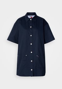 Tengerészkék rövid ujjú ingruha pamutból. Gombos eleje, két elülső zseb, valamint csíkos belsővel rendelkező gallér jellemzi.