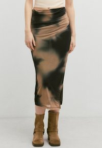 Knielanges, eng anliegendes Kleid mit einem Batikmuster in den Farbtönen Beige, Schwarz und Braun. Hergestellt aus glattem, leichtem Stoff.