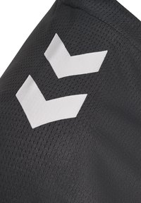 Zwarte sportieve stof met een gestructureerd oppervlak; twee witte chevronvormige ontwerpen zijn prominent weergegeven. Het patroon is lichtgewicht en ademend.