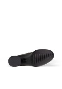 Sole di scarpa in pelle nera con gomma testurizzata per una migliore aderenza, caratterizzata da scanalature orizzontali e verticali, e un'area a motivo circolare nella punta.