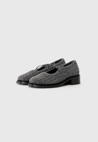 Pair of gray knit fabric shoes with black low block heels and lace-up details on a white background.