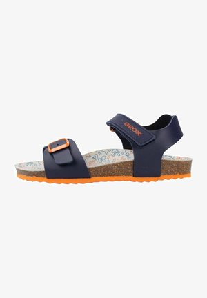 Navy blue sandal with adjustable strap, orange accents, and cork sole. Patterned insole features light blue and orange designs.
