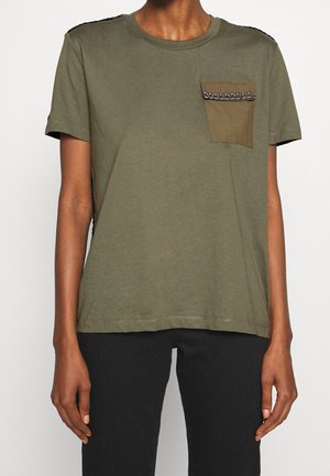 T-shirt vert olive avec un col rond, des manches courtes et une poche plaquée ornée d'une bande texturée. Tissu doux, coupe décontractée.