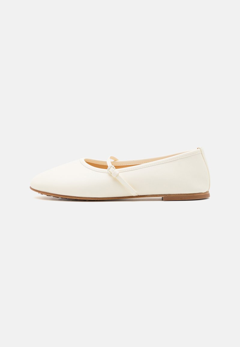 Cream ballet flats with a smooth exterior, round toe, a thin ankle strap, and a flat sole. Simple design with no additional embellishments.