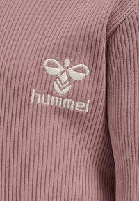 Rosa ribbat tyg med vit broderad logotyp som har bin och texten "hummel" placerad på bröstområdet.