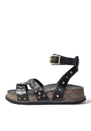 Black leather platform sandal with gold studs, adjustable ankle strap with gold buckle, and textured cork sole.