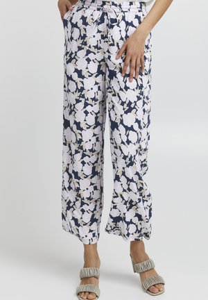 Leichte Blumenhose mit marineblauem Grund, weißen Blumen und grünen Akzenten. Das Design umfasst einen elastischen Bund und Seitentaschen.