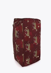 Red fabric bag featuring a leopard print with golden hardware accents and protective feet on the base. Rectangular shape with zip closure.