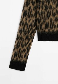 Pull en peluche à manches longues avec un motif léopard marron et noir et des poignets et ourlet noirs unis.