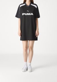 Czarna poliesterowa sukienka sportowa z krótkimi rękawami, z wzorem w białe i szare paski, logo PUMA z przodu oraz kołnierzykiem w serek.