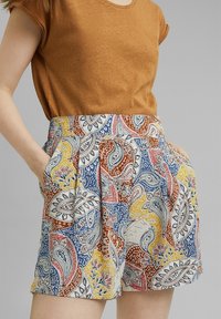 Pantalones cortos estampados con una cintura alta, que presentan un patrón paisley colorido en rojo, azul, amarillo y blanco. Incluyen bolsillos laterales.