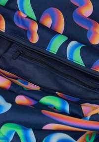 Mehrfarbiges Textil mit einem wirbelnden Muster auf einem dunklen Hintergrund, das eine sichtbare Reißverschlusstasche und einen glatten, strukturierten Stoff zeigt.