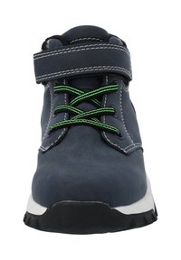 Zapato de ante navy con cuello acolchado, cordones verdes y correa de Velcro ajustable. Presenta una entresuela blanca y una suela externa de goma negra texturizada.