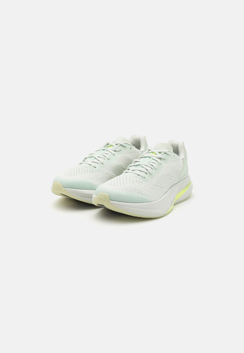 Hellgrüne Laufschuhe mit einem atmungsaktiven Mesh-Obermaterial, kontrastierenden gelben Akzenten, gepolsteter Sohle und runder Zehenform.