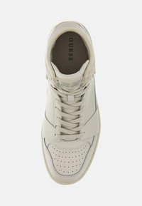 Sneaker alte in pelle beige con punta perforata, accenti testurizzati e cuciture grigie. Visibili lacci e soletta con marchio.