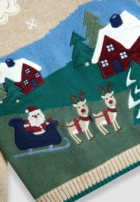 Strickpullover mit festlichen Motiven von Santa, zwei Rentieren und schneebedeckten Häusern in Rot und Blau, mit grünen Bäumen und einem elfenbeinfarbenen Rippenbund.