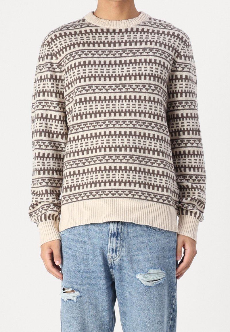 Stickad tröja i beige och brunt med geometriska mönster, rund halsringning, ribbade muddar och nederkant, lätt tyg och avslappnad passform.