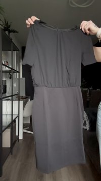 Grijs jurkje met korte mouwen, een getailleerde taille en een rechte snit. Gemaakt van soepele stof, met een subtiele glans en een elastische taille.