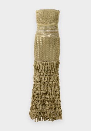 Strikket kjole i guld, med tube-top design, vævet tekstur og lang frynset kant. Udsmykket med vandrette bånd for ekstra interesse.