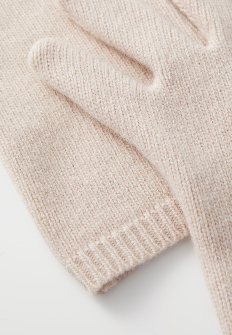 Knit gloves in soft, pale pink wool with ribbed cuffs, featuring a smooth texture and simple design for warmth and comfort.