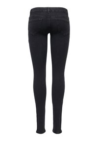 Jean skinny noir avec deux poches arrière, passants de ceinture et taille ajustée, vu de dos sur fond blanc.