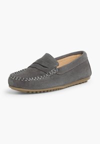 Mocassin en daim gris avec un accent cousu, design sans lacets, semelle en caoutchouc et bout arrondi, présentant une texture lisse et un minimalisme dans les détails.