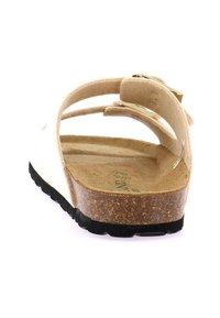 Sandali bianchi con soletta in sughero, cinturini in pelle e fibbia regolabile. Suola in gomma nera texturizzata per una buona aderenza. Vista posteriore che mostra i dettagli di costruzione.