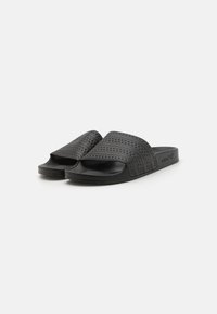 Sorte slidesandaler med en tekstureret overdel med perforeringer, flad sål og et bredt stropdesign for øget komfort.