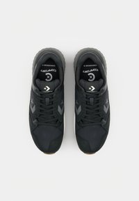 Sorte sneakers lavet af mesh og ruskind, med snørebånd, en polstret sål og kontrasterende grå elementer. Converse-logoet på tungen.