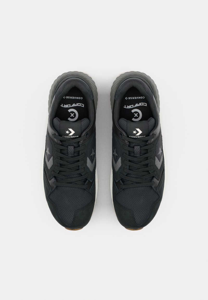 Sneaker nere realizzate con materiali in mesh e suede, dotate di lacci, suola imbottita e accenti grigi a contrasto. Logo Converse sulla linguetta.