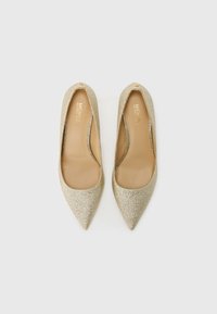 Gold glitter heels with a pointed toe, smooth inner lining, and an open side design. Metallic accents near the heel.