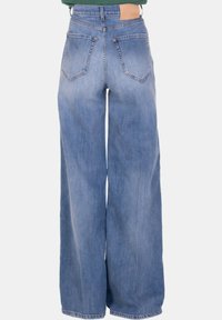 Jeans in denim blu chiaro a gamba larga con finitura sbiadita, design a cinque tasche e patch in pelle sulla vita posteriore.