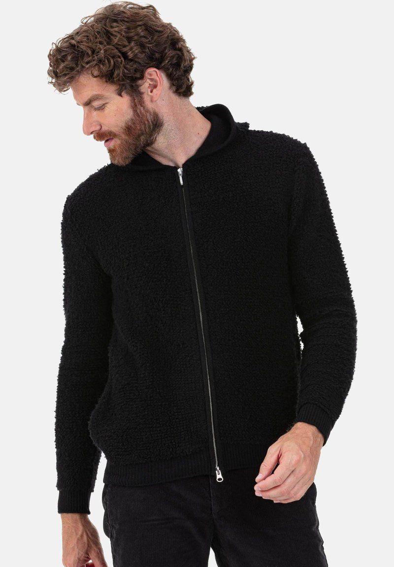 Schwarzer Kapuzenpullover mit Reißverschluss, flauschiger Textur und gerippten Bündchen. Verfügt über einen Frontreißverschluss und eine weiche, gefütterte Kapuze. Minimalistisches Design.