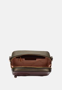 Borsa in pelle verde con texture, base marrone, chiusura con zip e interno chiaro con etichetta del marchio. Accentuata con dettagli in oro.
